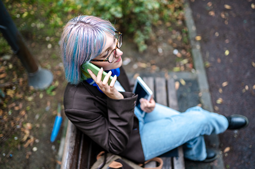 Young entrepreneur woman having business talk on the phone on the way to work