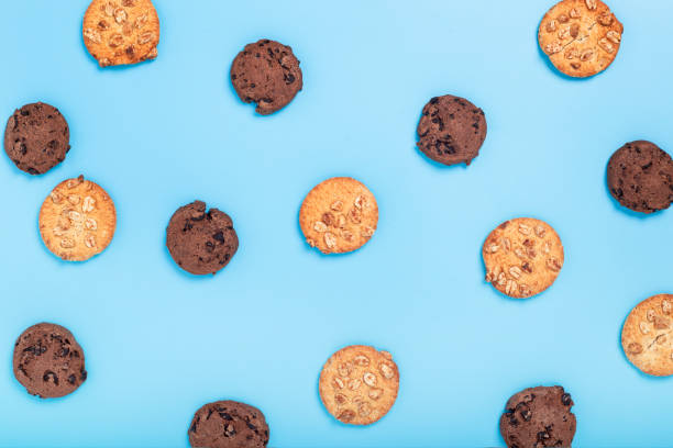 istock Chocolate cookies with chocolate, cookies with nuts on a blue background. Top view, flat lay. 1355857582