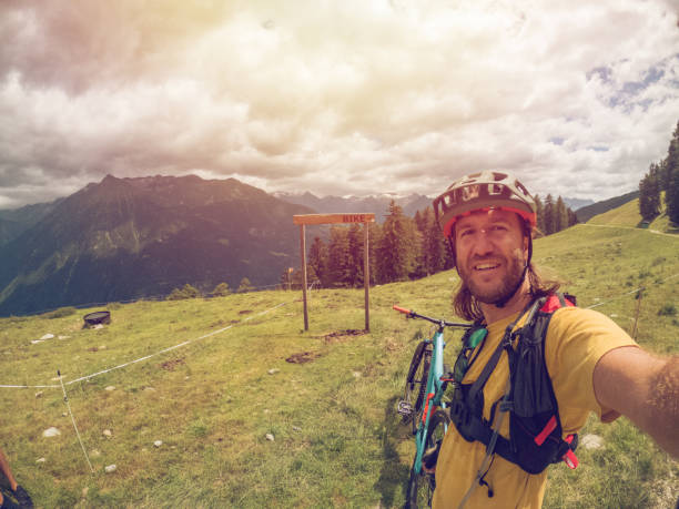istock Young man mountain biking takes cool selfie 1355858869