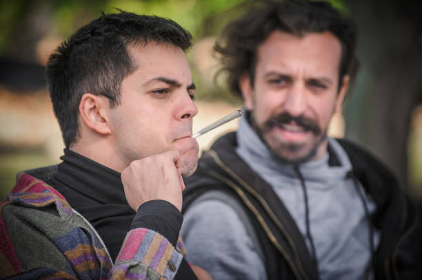 istock Two young friends smoking cannabis marijuana ganja or hashish joint 1355859008