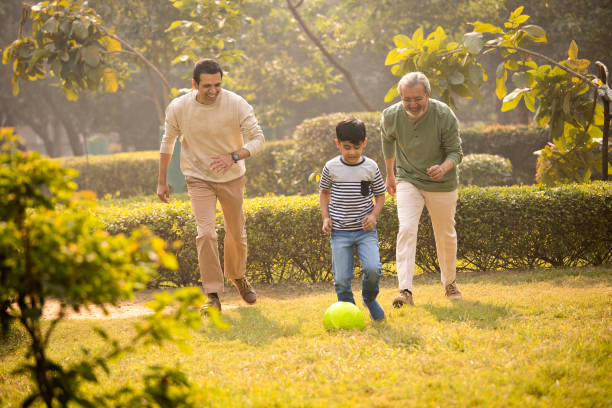 istock Three generation family playing with soccer ball at park 1355860922