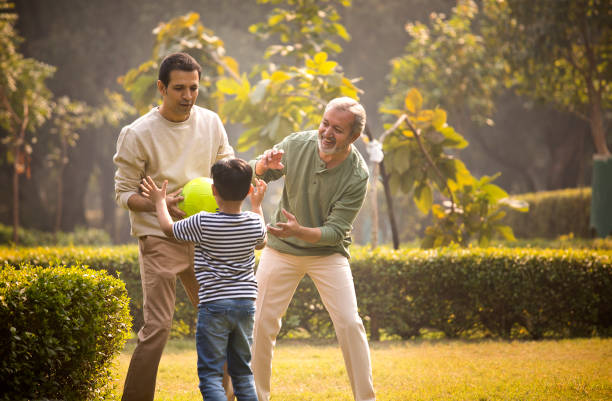 istock Three generation family playing with ball at park 1355861189
