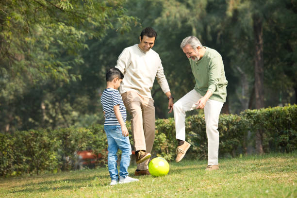 istock Three generation family playing with soccer ball at park 1355862909