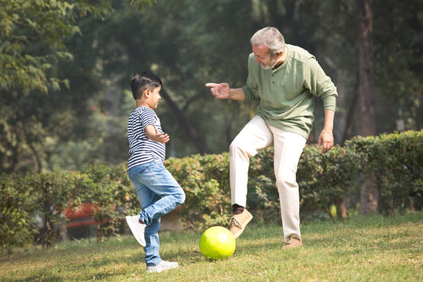 istock Senior man playing with grandson at park 1355862922