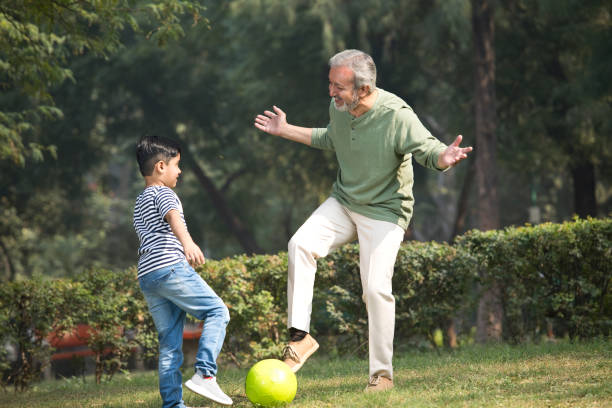 istock Senior man playing with grandson at park 1355862945