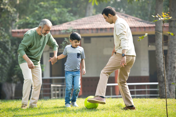 istock Three generation family playing with soccer ball at park 1355863125