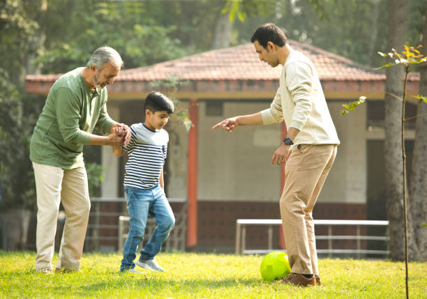 istock Three generation family playing with soccer ball at park 1355863151