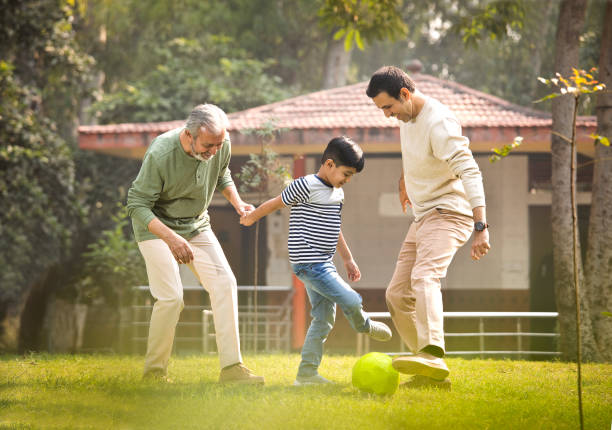 istock Three generation family playing with soccer ball at park 1355863181
