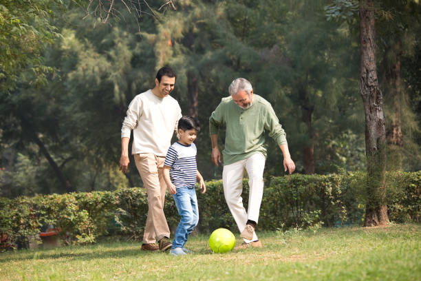 istock Three generation family playing with soccer ball at park 1355863238