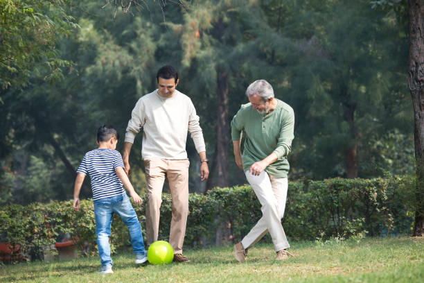 istock Three generation family playing with soccer ball at park 1355863272