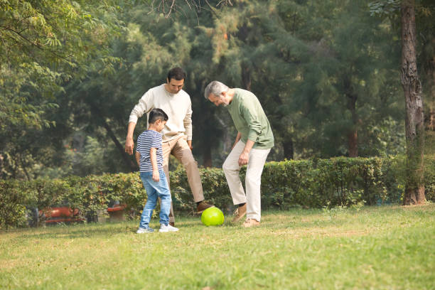 istock Three generation family playing with soccer ball at park 1355863363