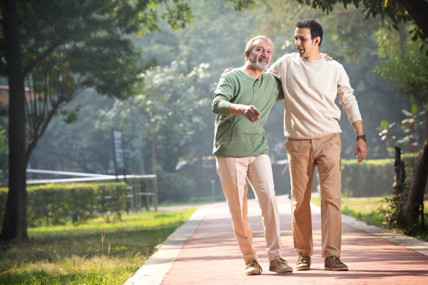 istock Happy senior man walking with son at park 1355864004