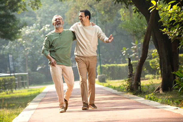 istock Happy senior man walking with son at park 1355864016