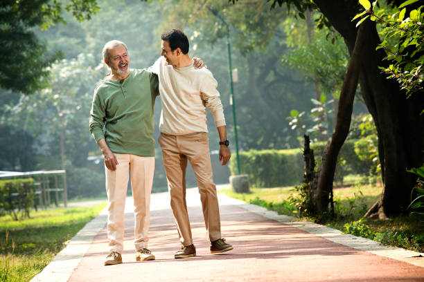 Happy senior man walking with son at park