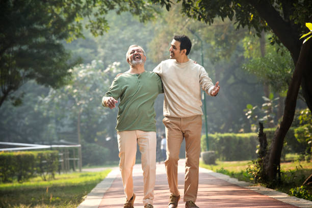 istock Happy senior man walking with son at park 1355864049