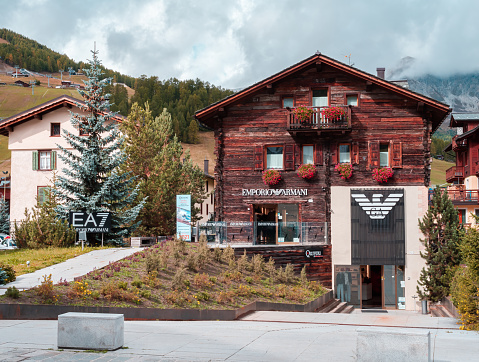 Livigno, Italy - September 29, 2021: Wooden house of Emporio Armani fashion store in a duty free town of Livigno, Italy.