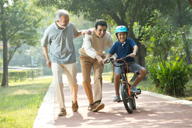 istock Boy learning bicycle with father and grandfather at park 1355869375