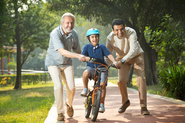 istock Boy learning bicycle with father and grandfather at park 1355869896