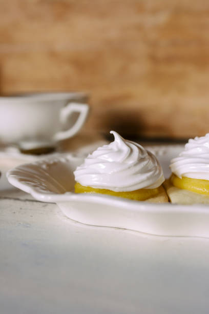 мини лимонный пирог отдельными порциями на элегантной белой тарелке - чайное время. традиционные из кухонь великобритании, франции, сша. - lemon meringue pie pie pastry crust portion стоковые фото и изображения