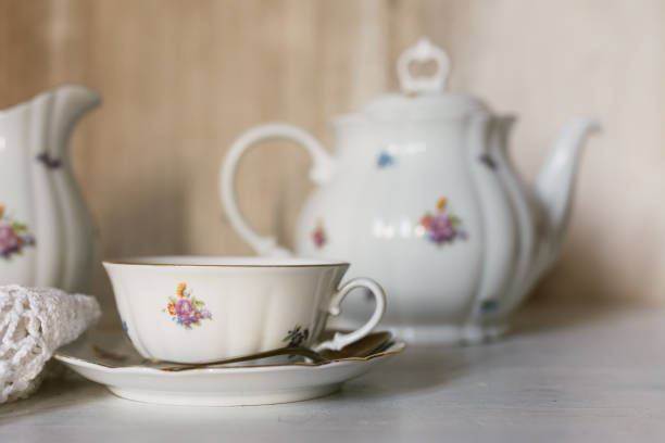 Breakfast tea served with fine china porcelain set with roses, in a rustic setting.