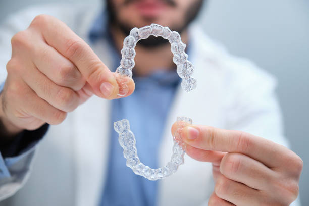 istock Unrecognizable orthodontist holding trainer dental braces. 1355874515