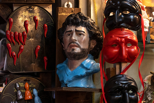 Naples, Italy - November 7, 2021. Traditional horns of fortune, Pulcinella masks and busts of Diego Maradona on San Gregorio Armeno street.