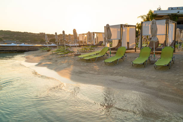 chaises longues vertes et lits de plage bruns sur la plage de sable blanc avec de l’eau de mer turquoise - sandy brown bay beach sand photos et images de collection