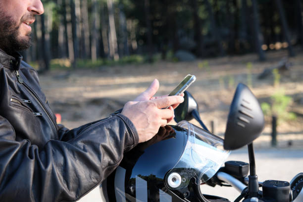 istock A handsome biker using mobile phone on a rural road. 1355882042