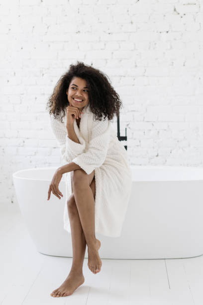 istock Young african american woman sitting on bath 1355886304