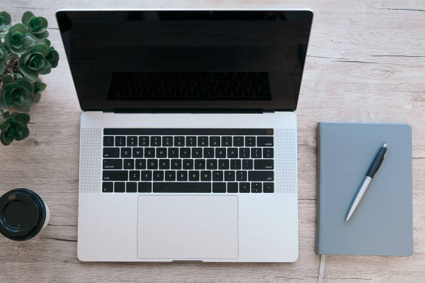 istock top view. laptop, notebook and pen on the table 1355886396
