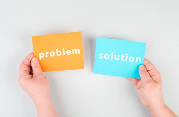 The words problem and solution are standing on orange and blue colored paper, brainstorming for new ideas, hands holding the meassa stock photo