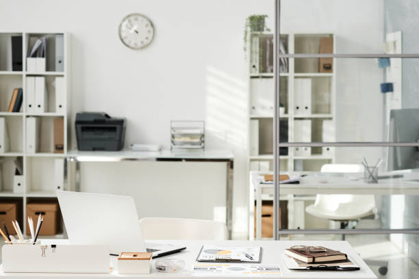 istock White minimalistic office interior furnished with shelves with documents, tables and chairs 1355893081