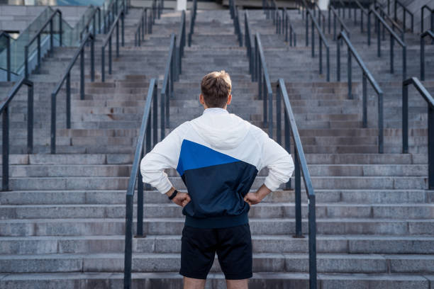 istock Young sportsman looking at steps, ready training outdoors 1355893784
