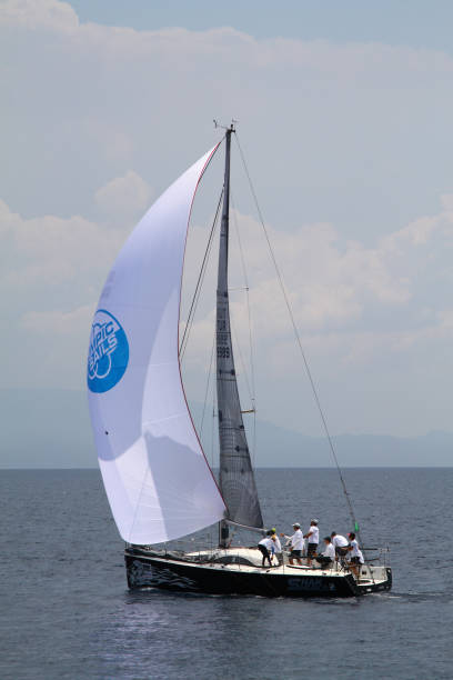 segelboote segeln bei windigem wetter im blauen wasser der ägäis - sailboat storm teamwork competition stock-fotos und bilder