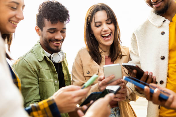 feliz grupo de jovens amigos usando smartphone na rua - adult student fotos - fotografias e filmes do acervo