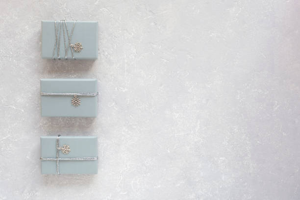 istock Grey Christmas gift boxes decorated with snowflakes on grey, copy space 1355902745