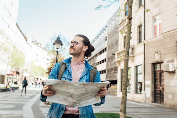 istock Young tourist with a map looking for a direction 1355905576