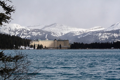 The hotel Fairmont Château Lake Louise taken in early winter of 2019 and snowcapped mountains.