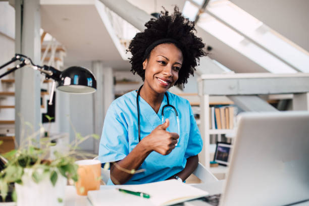 istock Young African-American doctor doing online checkups with her patients 1355906554