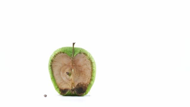 Green and half apple getting rot on a white background timelapse footage