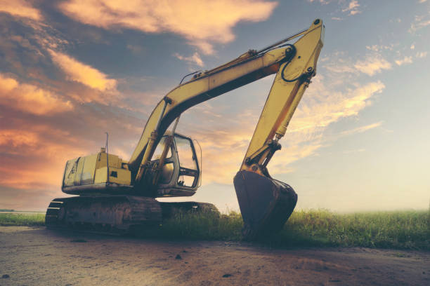 istock Excavator or backhoe on sunset background. Heavy construction equipment at construction site 1355914036