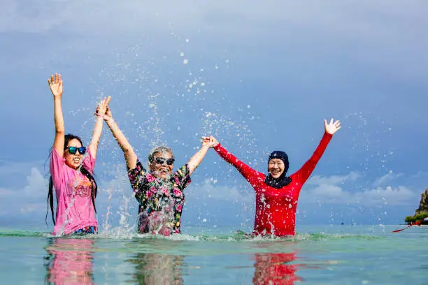 Photo of senior adult and daughter swimming in the beach