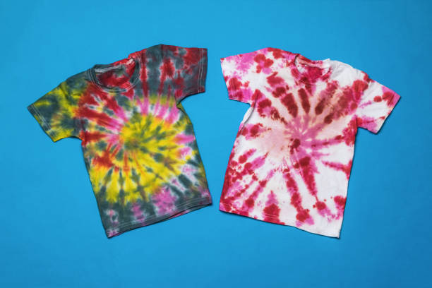 istock Two tie dye T-shirts on a blue background. Flat lay. 1355938013