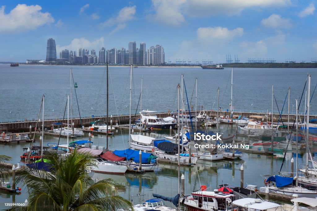 Raffles Marina in Singapore, and Forest City in Malaysia Vessels moored at Raffles Marina in Singapore, with apartment blocks that form the Forest City township in Johor Bahru, Malaysia in the background. City Stock Photo