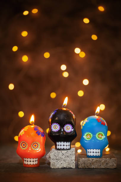 istock Typical Mexican skull painted candles on black background. Dia de los muertos. 1355941107