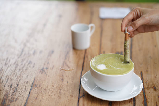istock Hot green tea served with cinnamon on hand. 1355943158