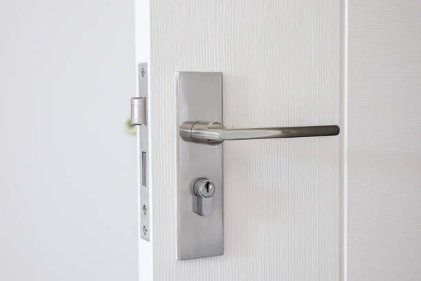 istock Modern door handle with keyhole on white door 1355944846