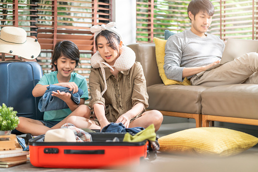 happy asian sweet family prepare travel exited asian family prepare packing cloth with suitcase luggage travel stuffs for family holiday vacation together at living room at home,happy travel together