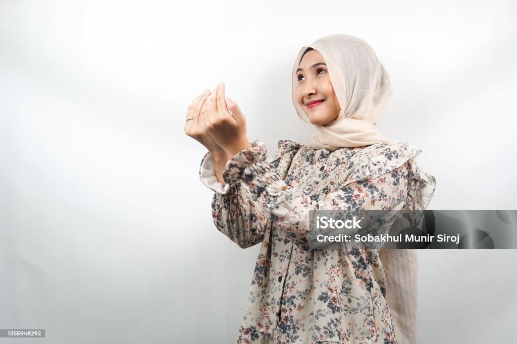 Beautiful asian young muslim woman praying, apologizing, sad, feeling guilty, asking forgiveness, fasting ramadan, islam, eid al fitr and eid adha, isolated on white background Islam Stock Photo