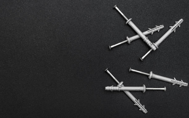 istock Screws with dowels on black background. Top view. Space for text. 1355948338